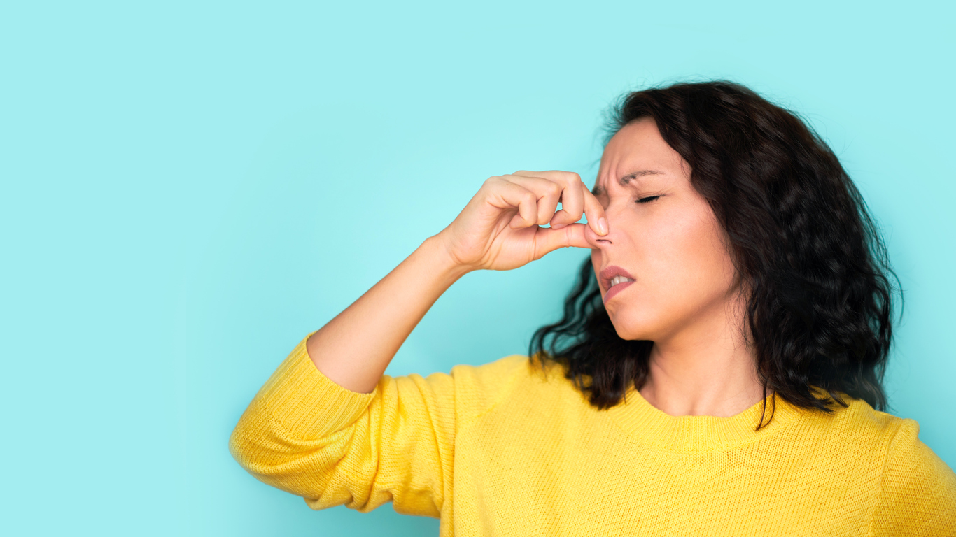 Woman Plugging Her Nose Due to Smell