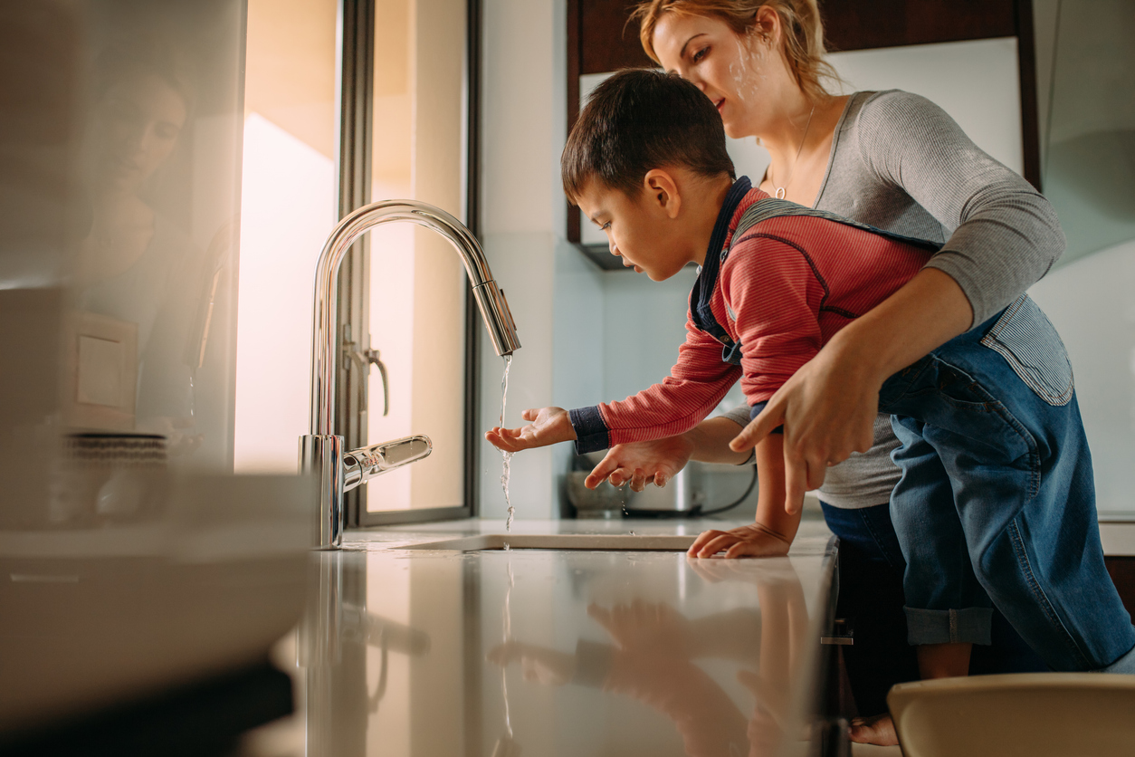 Mother and Child Washing Hands in Kitchen Sink