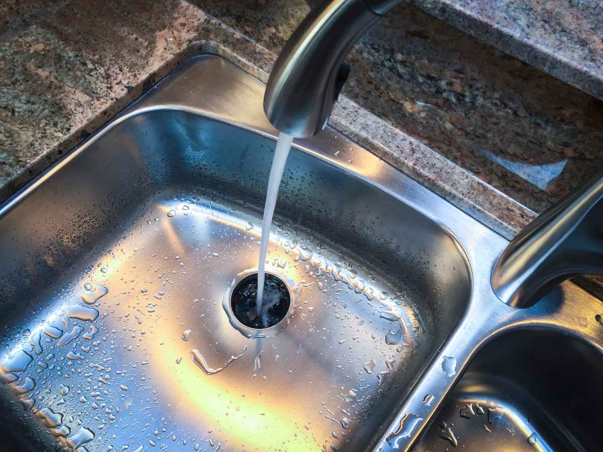 Water flowing down the drain of kitchen sink.