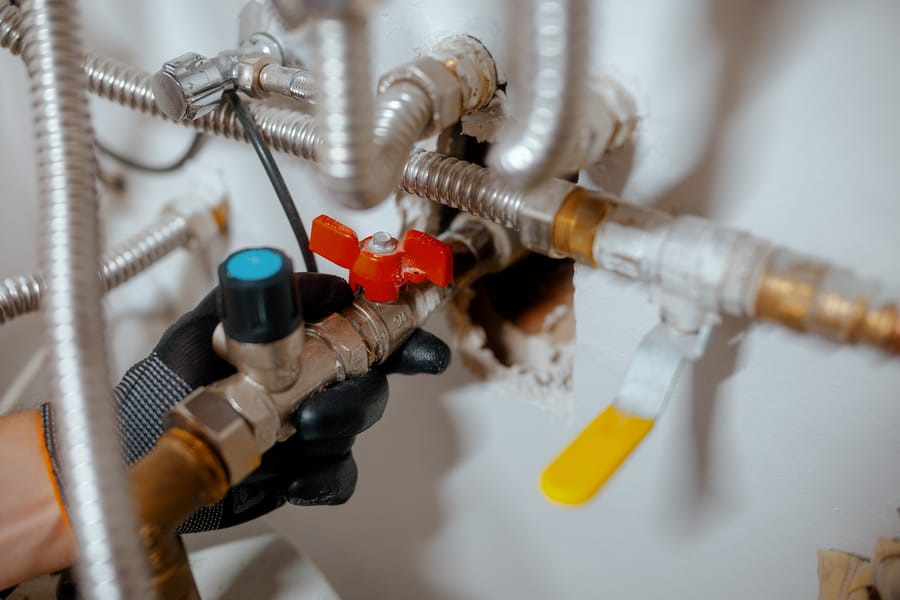 Plumber's hand adjusting a home water valve