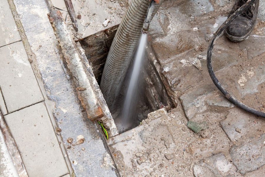 Plumbers using hydro jetting technique to clear tough, stubborn clogs