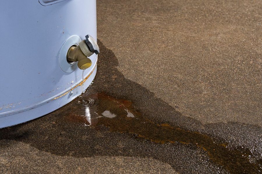 Water heater leaking onto the basement floor. Image shows floodstop and the bottom of the tank.